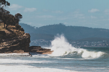 Fototapeta na wymiar big waves crashing against rocky shoreline in Tasmania, Australia