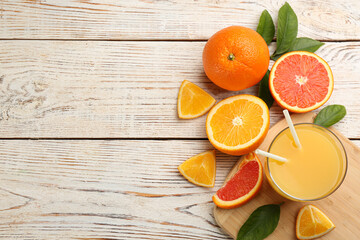 Delicious orange juice and fresh fruits on white wooden table, flat lay. Space for text