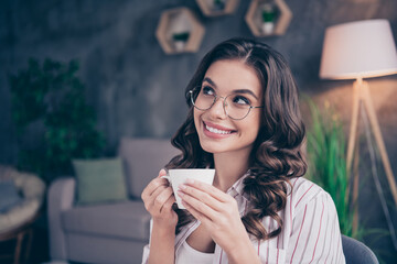 Photo of optimistic brunette curly hairdo lady look drink coffee from home wear white shirt sit