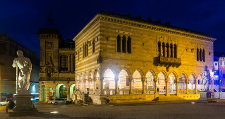 Fototapeta na wymiar View of lighted Gothic building of Loggia del Lionello - town hall of Udine on central city square of Piazza liberta, Italy