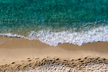 spiaggia e mare o1- mare verde, spiaggia dorata con impronte e spuma bianca.