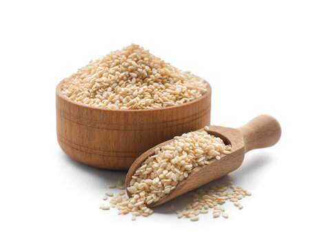 Wooden bowl and scoop with sesame seeds on white background