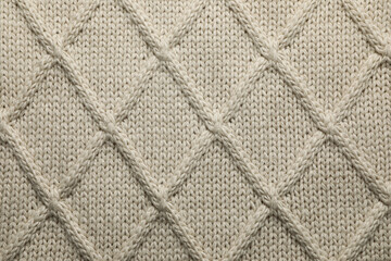 Fototapeta premium Beige knitted wool texture as background, top view