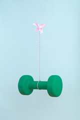 Solo pink origami butterfly working alone to light heavy burden of exercise weight. Minimal art struggle and strive concept.