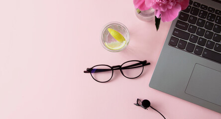 The concept of recording courses, podcast, lesson. Laptop, microphone, glasses on a pink background...