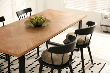 Stylish wooden dining table and chairs in room. Interior design