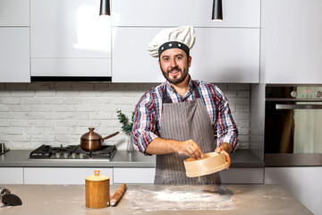 Portrait of a man smiles in the kitchen.