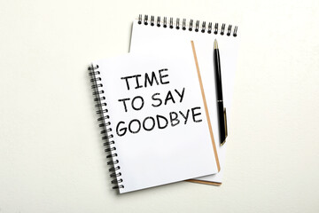 Notebook with text Time to say goodbye on white background, flat lay
