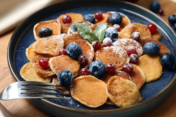Cereal pancakes with berries on wooden board, closeup
