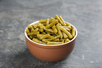 Canned green beans in bowl on grey table