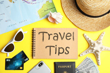 Flat lay composition with tourist items and notebook on yellow background. Travel Tips