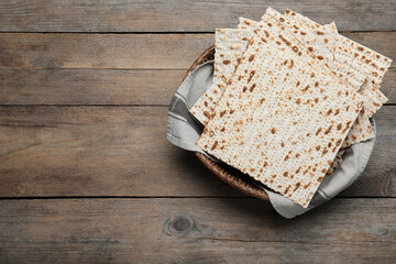 Traditional matzos in basket on wooden table, top view. Space for text