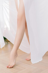 Running girl in a silk robe. Legs close-up, blurred background and selected focus. The bride's lifestyle.
