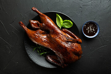 Peking duck with sauce on a dark table