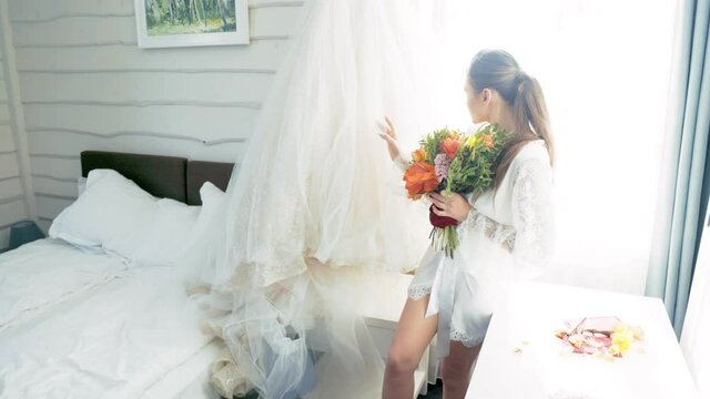 the bride is sitting on the bed