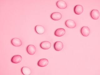 Creatively painted eggs in pastel colors on pink background. Happy Easter concept. Flat lay.