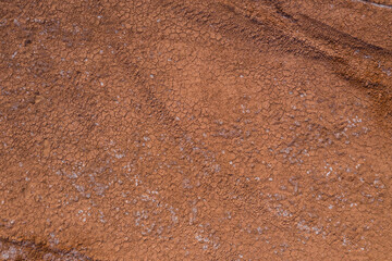 The texture of dry earth is red. View from above.