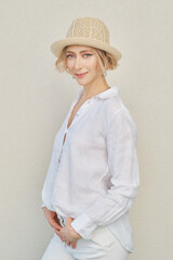 Lifestyle portrait of beautiful woman in white shirt and straw hat