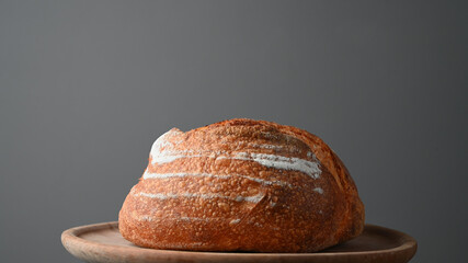 Round baked bread on a wooden tray