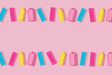 Hair rollers or curlers creative pattern or frame on pastel pink background. Retro style aesthetic. Fun idea for salons.