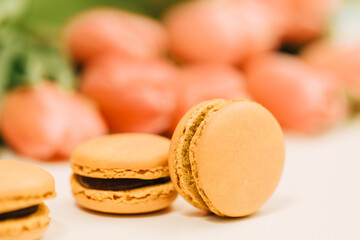 Yellow macarons with pink tulips in the background