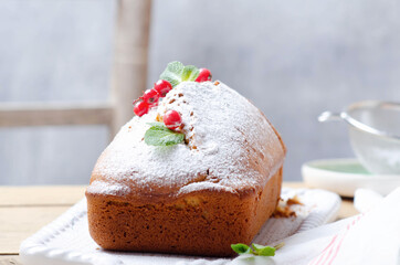 Plum cake with yougurt and with red currant over  white wooden tray.
