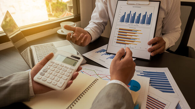 Businessman analyzes income charts and graphs with a laptop computer, a modern calculator. Closely analyze business and business strategy concepts.