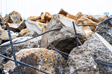Large concrete stones and metal rods. Construction waste after dismantling the old building. Close-up