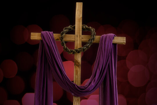 wooden cross, crown of thorns and purple fabric