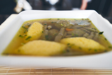 Suppe mit Nockerl, Leberspätzle, kleinen Leberknödel , Kurkuma und Kräutern servieren