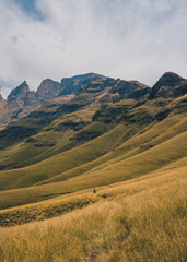 Hiker walking through the valley of Drakensburg, South Africa. October 2019