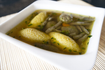 Suppe mit Nockerl, Leberspätzle, kleinen Leberknödel , Kurkuma und Kräutern servieren
