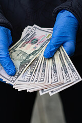 Holding bills with blue gloves on 