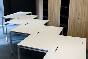 Fragment of an empty office space with tables and cabinets.