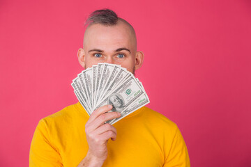 European man on pink red background with fan on 100 dollars positive isolated space