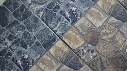 decorative surface of fragments of building interior tiles in gray and brown colors connected by edges, floor or wall covering with finishing stone in dark colors
