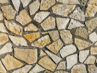 Stone masonry wall surface. Rock pieces and concrete mosaic wall background. Rough stone textured background. Brickwork backdrop.