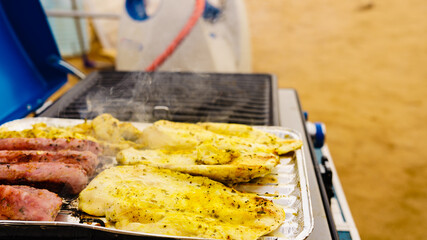 Sausages and chicken meat on grill