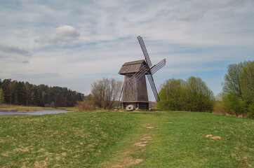 Beautiful spring landscape with wooden windmill. Nature and travel. Russia, Pskov Oblast,...