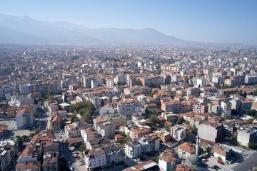 Aerial view of city with apartments on the background of mountains.