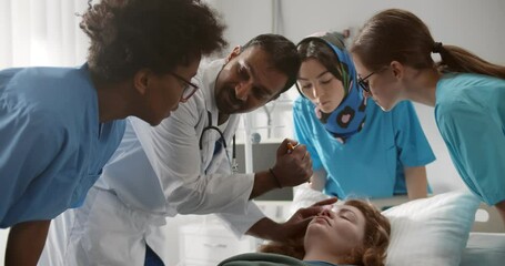 Tea of residential doctors examining patient in emergency room at hospital - Powered by Adobe