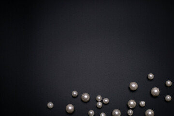 Pearls on the black background, with free space for text. Top view, elegant flat lay. Beautiful...
