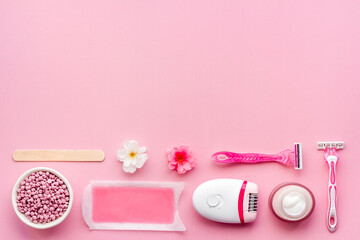 Pink epilator with wax strips and razor for removal of unwanted hair. Flat lay