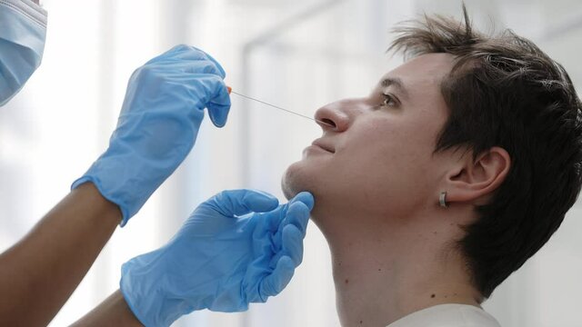 Medical worker in safety gloves taking PCR corona virus sample in health clinic. Doctor uses respiratory swab test. Concept of Covid research and diagnostic.