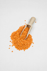 a handful of red lentils on a white table 