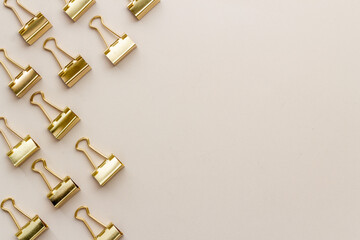 Frame of stationery golden paper binder clips top view. Office supplies pattern