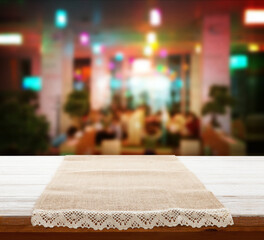 Canvas napkin with lace, tablecloth on wooden table and pizzeria interior. Can used for display or montage your products. Selective fokus.