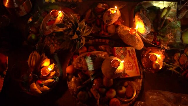 Hindu devotee offer prasad , fruits, vegetables and other items and light lamp or diya, to pray sun God, at a lake during Chhath Puja