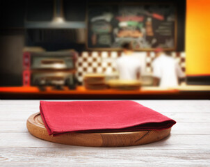 Napkin and pizza board on wooden desk top view mock up. Pizzeria interior. Selective focus.