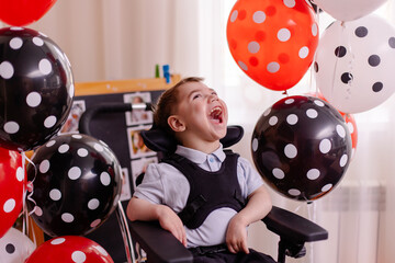 Happy Boy with cerebral palsy celebrates his birthday. Disabled person in a wheelchair in air...